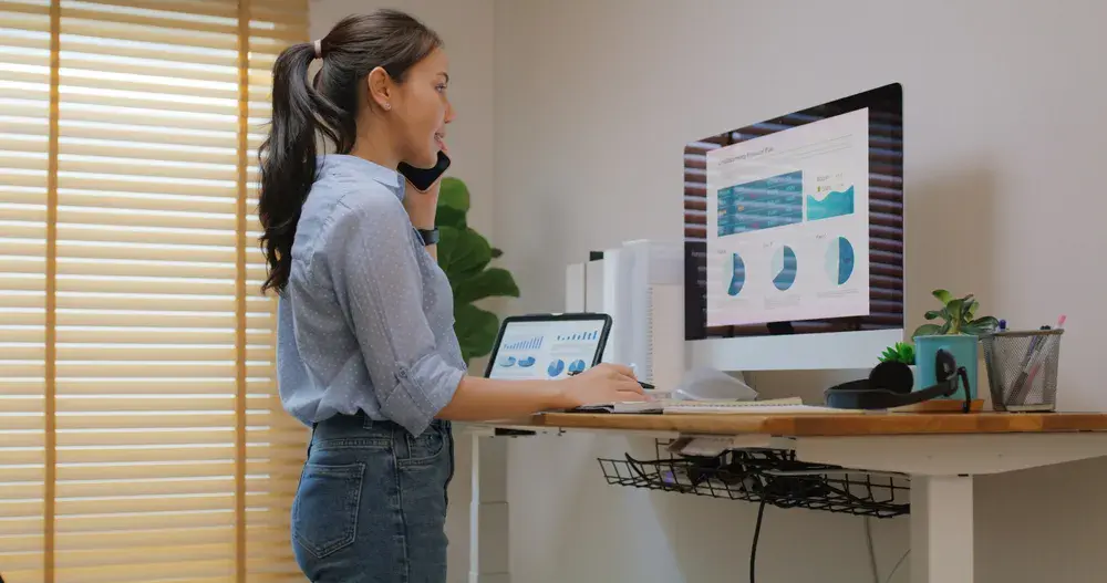 Modern home office setup with electric adjustable desk showing how remote workers use storage in Singapore for better workspace organization.